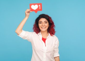 Beyaz gömlekli kadın elinde üzerinde kalp ikonu olan kırmızı bir bildirim tutuyor.