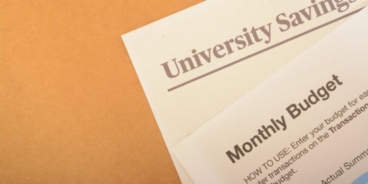 Üzerinde University Savings ve Monthly Budget yazan evraklar masada duruyor.