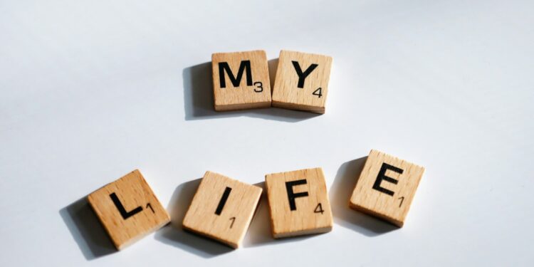 Beyaz bir zemin üzerinde ahşap harflerden oluşan My Life yazısı.