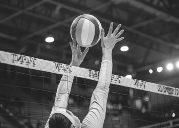 Salonda file önünde topa doğru ellerini uzatan voleybolcu.