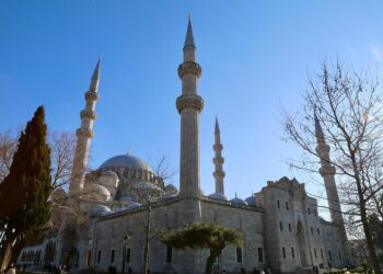 Açık mavi gökyüzü altında yükselen minareleri ve kubbesiyle tarihi cami