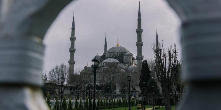 Sütunların arasından görünen kubbe ve minareleriyle tarihi cami.