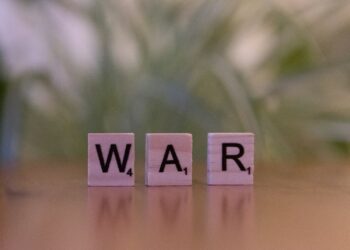 Ahşap Scrabble harfleriyle yan yana dizilmiş 'WAR' kelimesi duruyor.