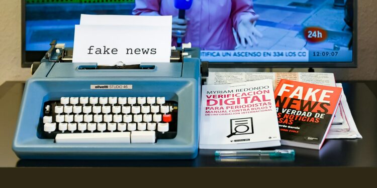 Üzerinde fake news yazan daktilo ve arkasında haber kanalı açık televizyon.