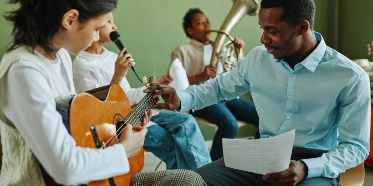 Bir müzik öğretmeninin çocuklara enstrüman çalmayı öğrettiği neşeli müzik dersi.
