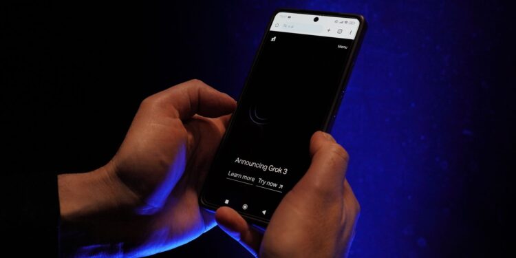 Karanlık bir ortamda ellerinde akıllı telefon tutan bir kişinin yakın plan görüntüsü.