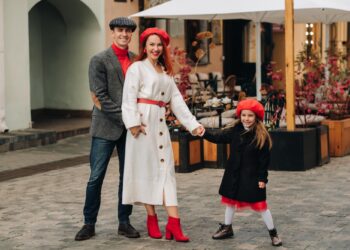 Sonbahar parkında birlikte yürüyen mutlu anne baba ve çocuk.