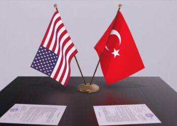 Masada duran ABD ve Türkiye bayrakları ile resmi evraklar