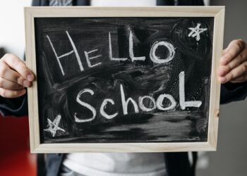 Kara tahta üzerinde 'Hello School' yazısının yazılı olduğu okul tabelası.