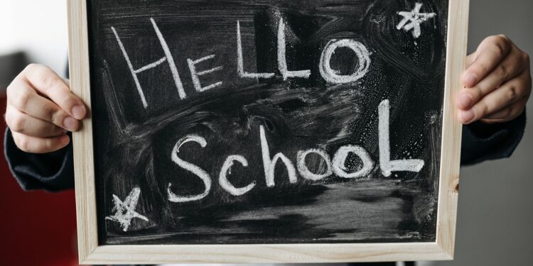 Kara tahta üzerinde 'Hello School' yazısının yazılı olduğu okul tabelası.